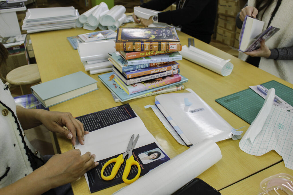 Kumamoto International School parents wrapping books for the school library, supporting IB student learning in Kyushu, Japan.